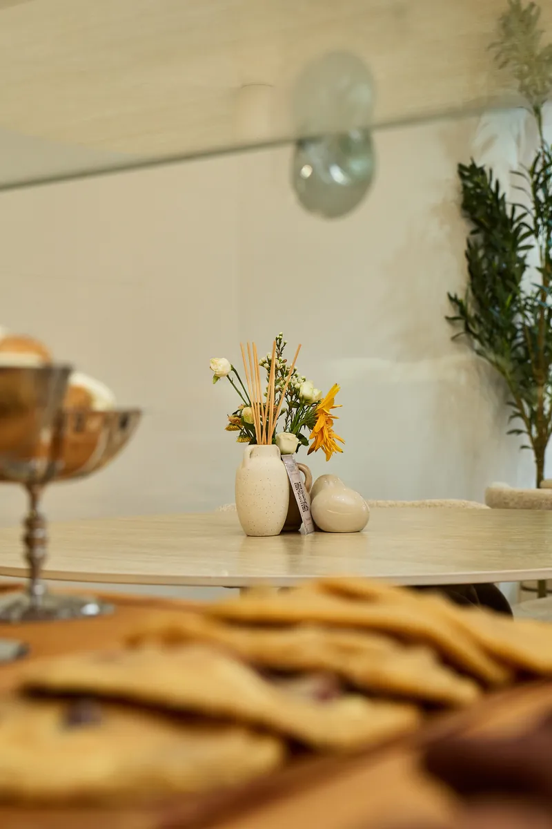 Hausgemachte Cookies vor einem Tisch mit kleiner Blumenvase