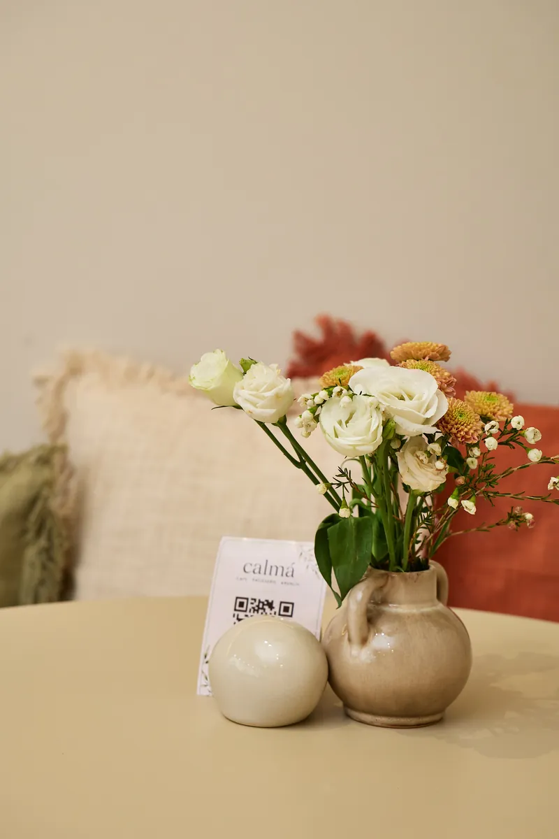 Krug mit weißen Rosen und calmá-Tischkarte