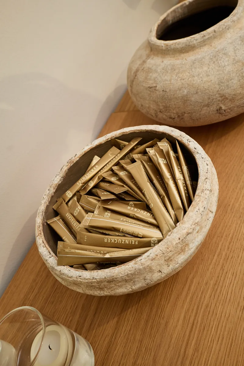Goldene Zuckersticks in einer Steinschale auf Holz